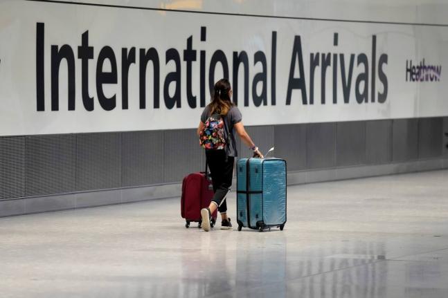 FILE - A passenger arrives from a flight at Terminal 5 of Heathrow Airport in London, August 2, 2021. (AP Photo/Matt Dunham, File)