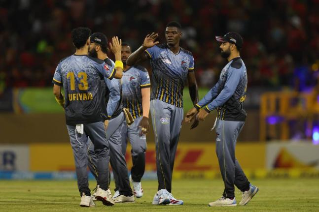 Antigua and Barbuda Falcons paceman Alzarri Joseph (second right) is congratulated by teammates for taking one o his four wickets during their Republic Bank Caribbean Premier League cricket game against the Guyana Amazon Warriors at the Providence Stadium 