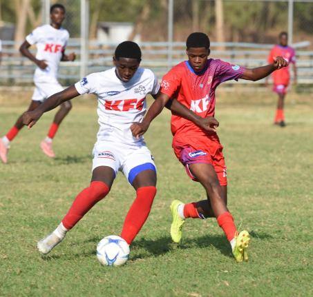 Camperdown High School’s Oneil Patrick (left) and Bridgeport’s Matthew McLarty compete for the ball during their Manning Cup football clash at the Dunbeholden playing field yesterday.