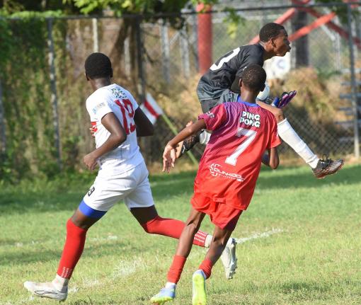 Bridgeport High goalkeeper Malik Higgins (right) gathers the ball ahead of Oneil Patrick (left) from Camperdown High during their Manning Cup football clash at the Dunbeholden playfield on Wednesday. Also in the picture is Qwayne Brown  of Bridgeport.