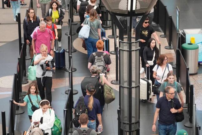 Travelers queue up to pass through the south security checkpoint in Denver International Airport in the USA on Wednesday, July 2, 2025. 