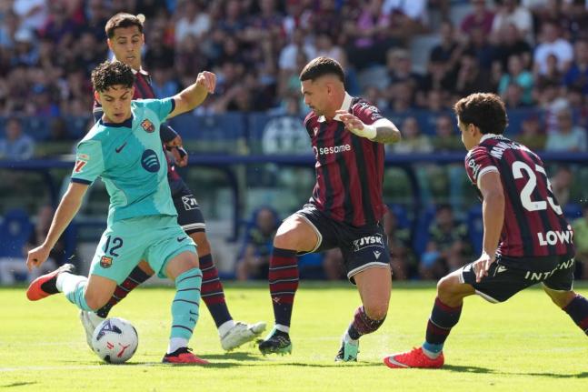 Barcelona’s Xavi Espart (left) scores his side’s first goal during the Spanish La Liga match between Levante and Barcelona in Valencia yesterday. 