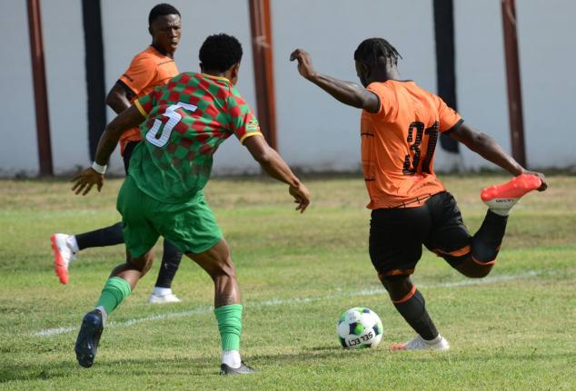 Alton Lewis (right) of Tivoli Gardens prepares to take a shot during yesterday’s Jamaica Premier League match against Humble Lion at Edward Seaga Sports Complex. At left is Shawn Campbell of Humble Lion. 