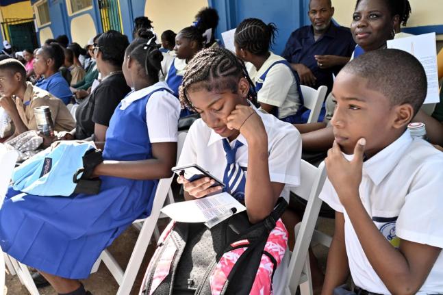Twins Kendra and Kai Lall, (right) 8th  graders coming from Hydel seated with students at the ceremony of the opening of the merged Hydel Cumberland High in St Catherine on September 7. 
