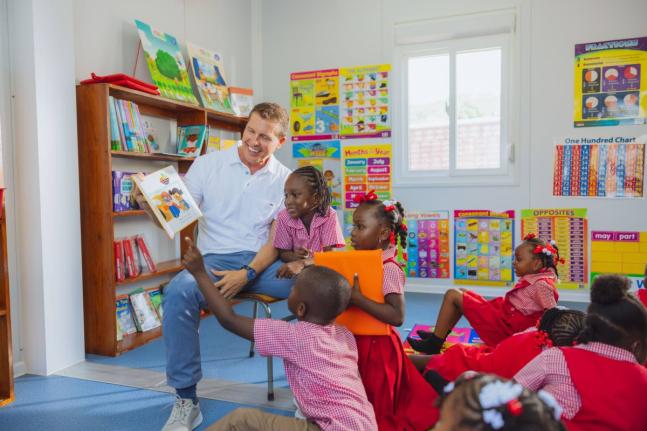 Executive Chairman Sandals Resorts and President Sandals Foundation, Adam Stewart reads to students of Culloden Infant inside newly constructed school library provided and resourced by the Sandals Foundation.