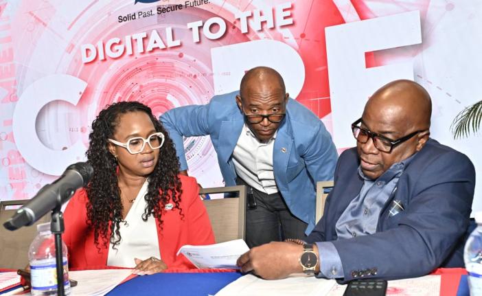 Xavier Allen (centre), CEO of FHC Credit Union, in discussion on the institution’s financial report with Nickeisha Walsh, treasurer, and Wayne Jones, first vice-president of FHC Credit Union, at the First Heritage Co-operative Credit Union Limited’s 14