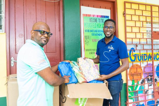 Omar Wright, lead, environment and community development, at the JN Foundation, hands over back-to-school-supplies to Roan Green, principal of Petersfield High School in Westmoreland. The JN Foundation made the donation to the institution during a visit to