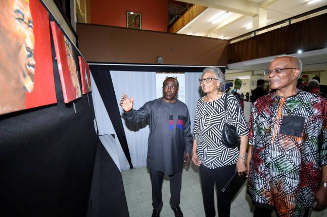 Professor Hopeton Dunn (left) introduces an art piece from his collection to former Governor General Sir Kenneth Hall (right) and his wife Rheima Hall at the opening of the ‘Kgotla!’ African Art and Artifact Exhibition at the Main Library of The Univer