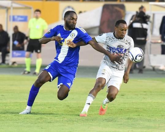 Cavalier SC’s Nicholas Hamilton (right) comes under pressure from Portmore United’s Clifford Thomas during their Concacaf Caribbean Cup football match at the National Stadium yesterday.