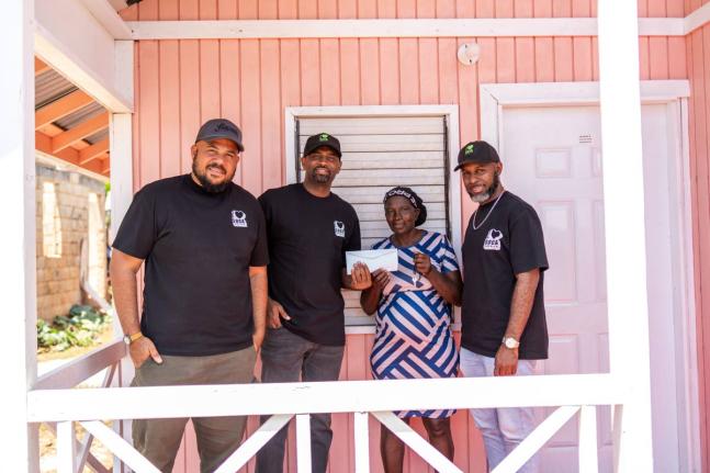 Hyacinth Crowe (second right) receives the keys and title to her new home in Newcombe, Treasure Beach, St Elizabeth on September 10, from I Love Soca directors (from left) Andrew Bellamy, Ian Bourne and Denver Holt. The home was provided in partnership wit