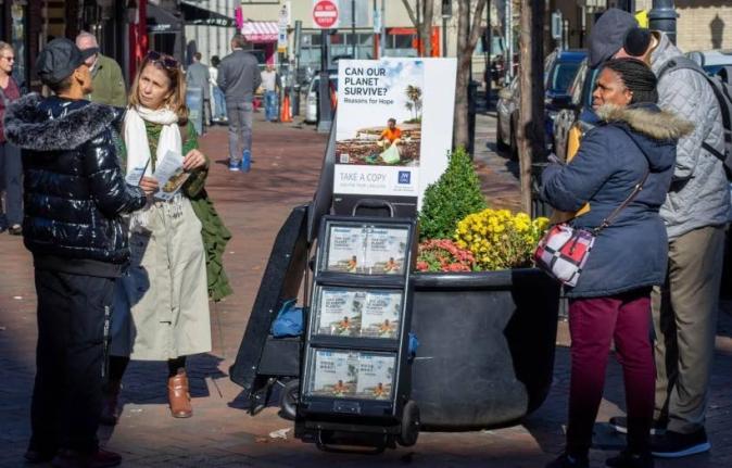 
A woman shares Jehovah’s Witnesses’ literature with a passerby in downtown Pittsburgh on November 13, 2023. 