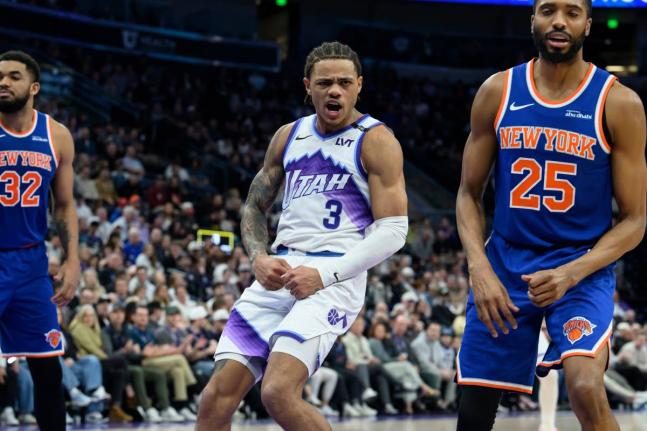 AP Utah Jazz guard Keyonte George (centre) flexes after making a contested shot over New York Knicks guard Mikal Bridges (right) during the second half of an NBA basketball game on March 11 in Salt Lake City. 