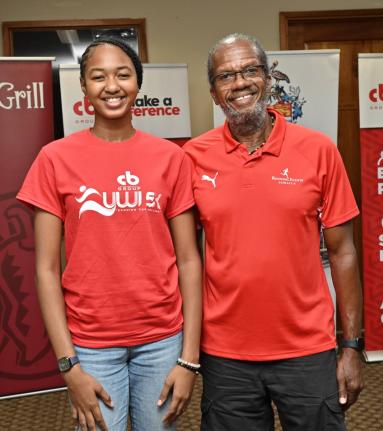 Quacian Stewart (left), recipient of the Franno Claudia Francis Carnigan Scholarship, stands beside UWI 5K organiser, Alfred ‘Franno’ Francis, during last Thursday’s launch at the school grounds. 