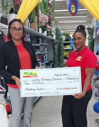 Tena McIntosh (right), store manager at Fontana Pharmacy in Savanna-la-Mar, and Nicole Grant (left), vice-principal of Unity Primary School, pause for a photo following the official cheque presentation ceremony.