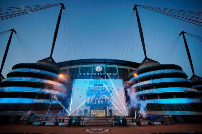 A banner celebrating their title win is illuminated outside Manchester City’s Etihad stadium in Manchester, England, Saturday, May 20, 2023. 
