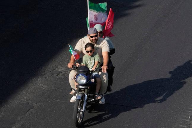 A family ride on a motorcycle during a state-organized motorcycle parade called ‘Janfada,’ meaning ‘Sacrifice for Iran,’, in Tehran, Iran, Friday.