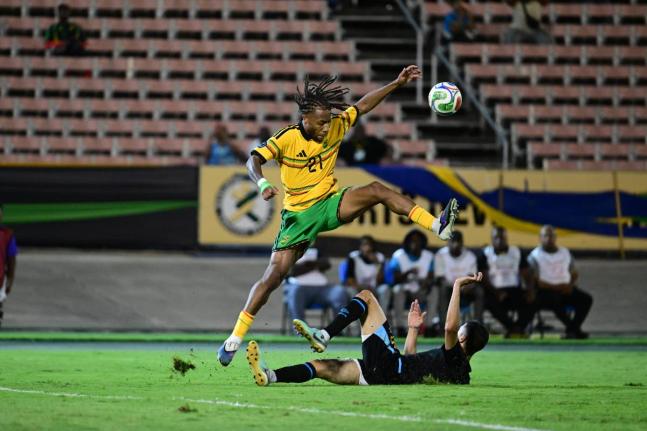 
Reggae Boy Rumarn Burrell hurdles a challenge during a Concacaf Nations League football match against Guatemala at the National Stadium on Friday night.