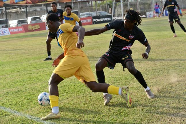 Deonjay Brown (right) of Montego Bay United and Adriel George of Racing United battle for the ball during their Jamaica Premier League match  at the Waterhouse Mini Stadium yesterday. Rudolph Brown/Photographer