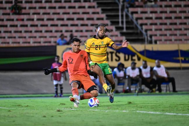 Jamaica’s Rumarn Burrell (right) puts the ball past Guatemala’s goalkeeper Kenderson Navarro during their Concacaf Nations League match at the National Stadium on Friday night. Jamaica won 3-2. 