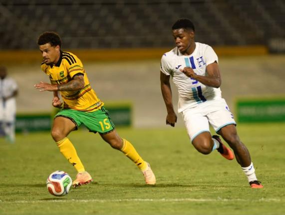 Reggae Boy Joel Latibeaudiere (left) and Honduras’ goalscorer Keyrol Figueroa go in chase of a ball during their Concacaf Nations League game at the National Stadium yesterday.
