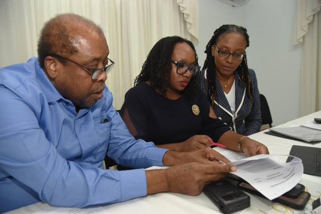 Trade unionist Lambert Brown (left) goes through documents with Dr Jubilee Brown-Service (centre), president of the Jamaica Medical Doctors Association (JMDA) and Dr Renee Badroe (right), Immediate Past President of the JMDA, during a press conference at t